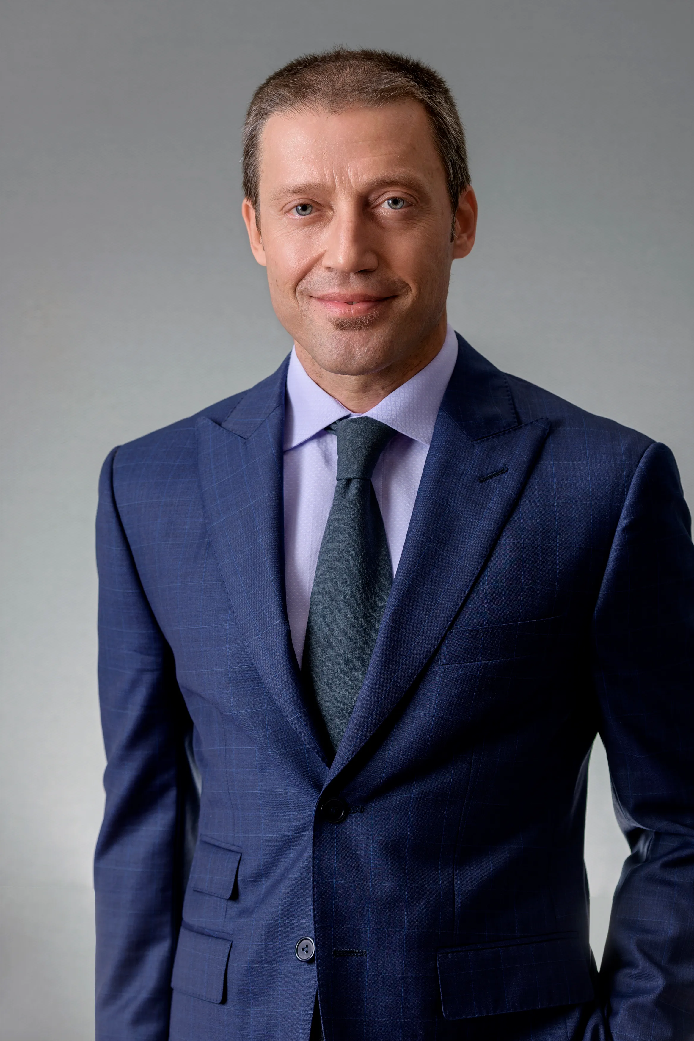 Executive headshot of a man in a navy suit