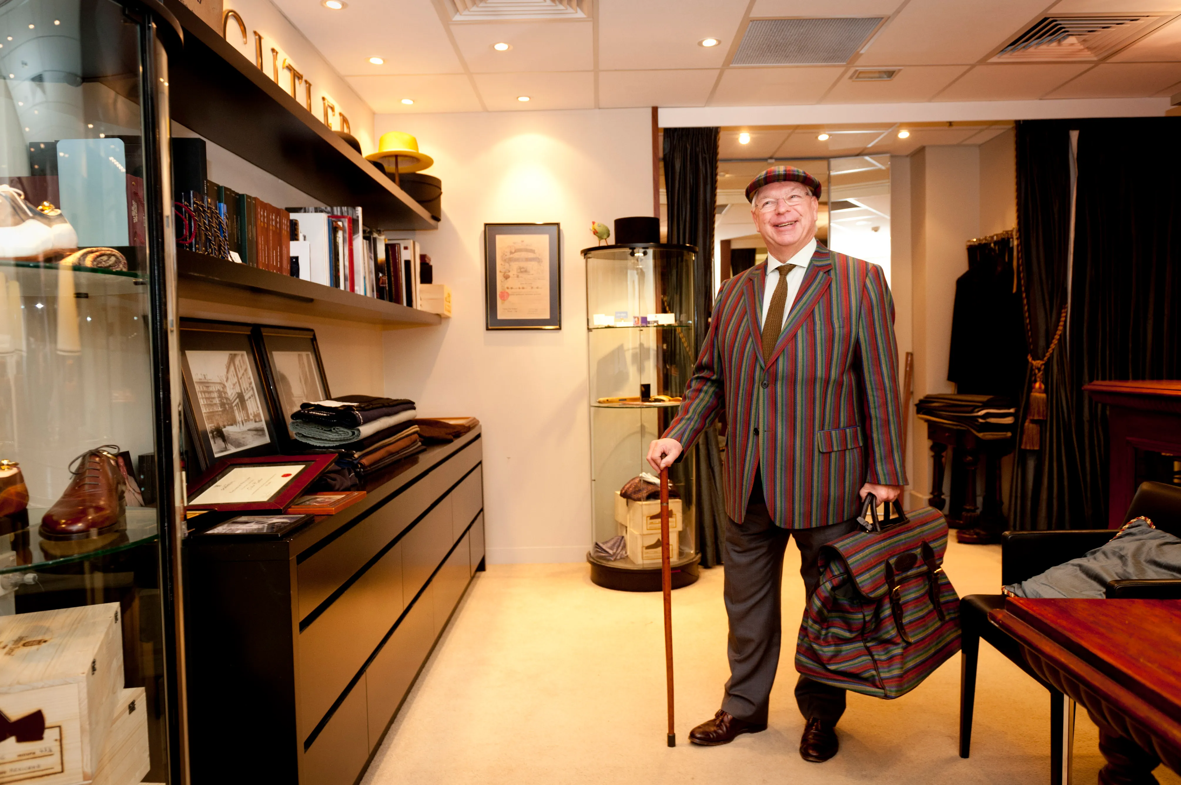 A master tailor photographed among the cabinets of his own fitting rooms