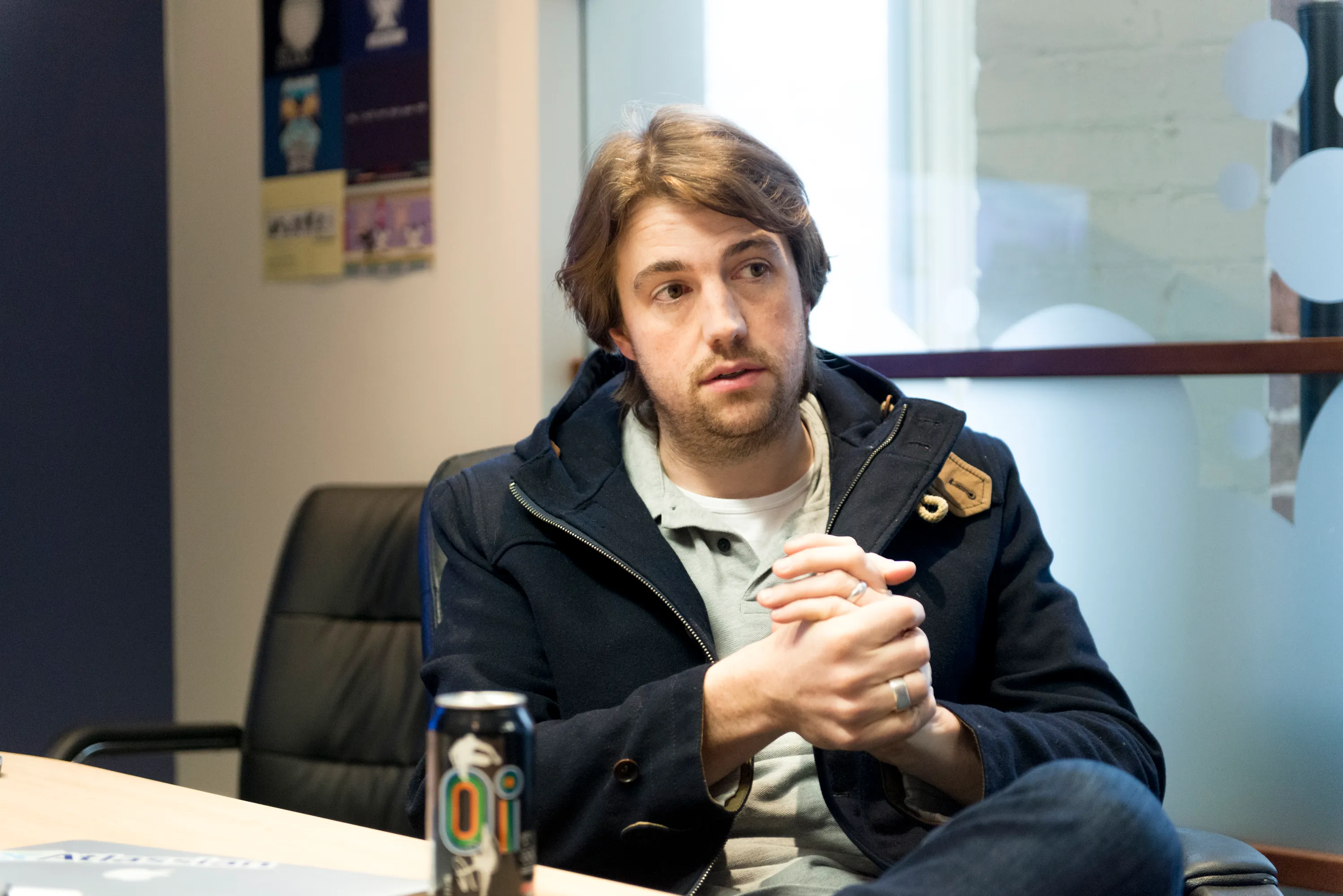 A technology founder photographed on a couch in his own office