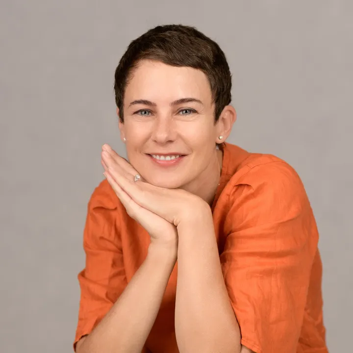 The same woman with a soft smile, her head resting on her hands